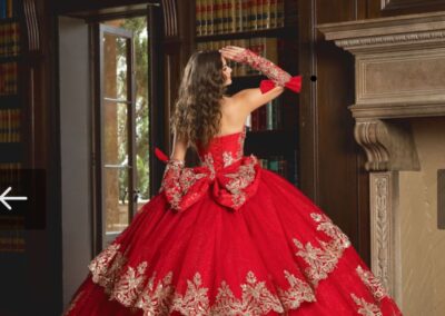 Red quinceañera ball gown with gold embroidery at Hem & Her Bridal in Tucson, AZ